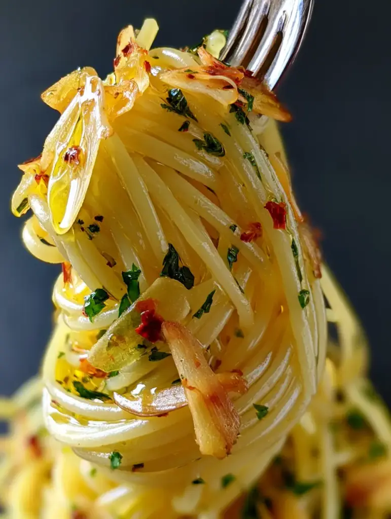 Spaghetti Aglio e Olio: The Ultimate Guide to Perfect Roman Pasta 1 Close-up of toasted golden garlic slivers and emerald parsley trapped in olive oil on spaghetti strands.