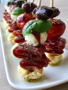 Close-up of Antipasto Skewers showing the mahogany balsamic glaze drizzle and herb-infused tortellini. (Antipasto Skewers)