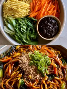 Close up of long egg noodles in a dark garlic soy sauce with julienned carrots. (lo mein noodles)